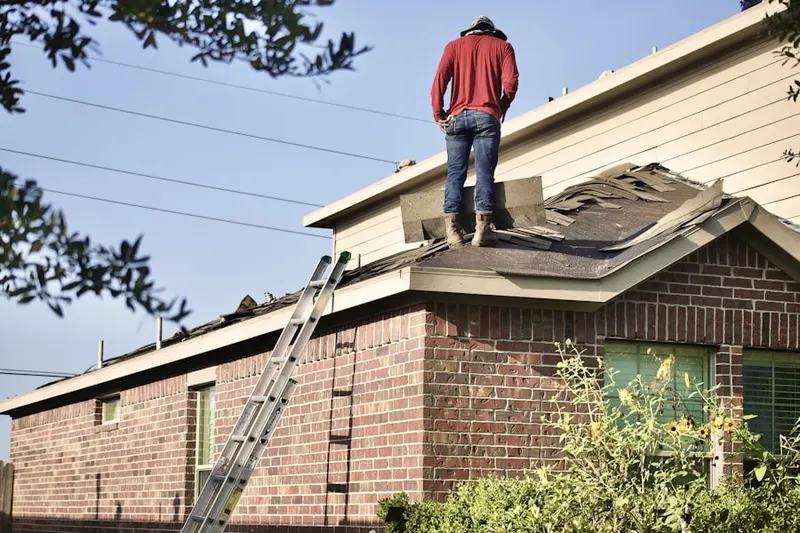 Professional roofer working on a residential roof in Harp